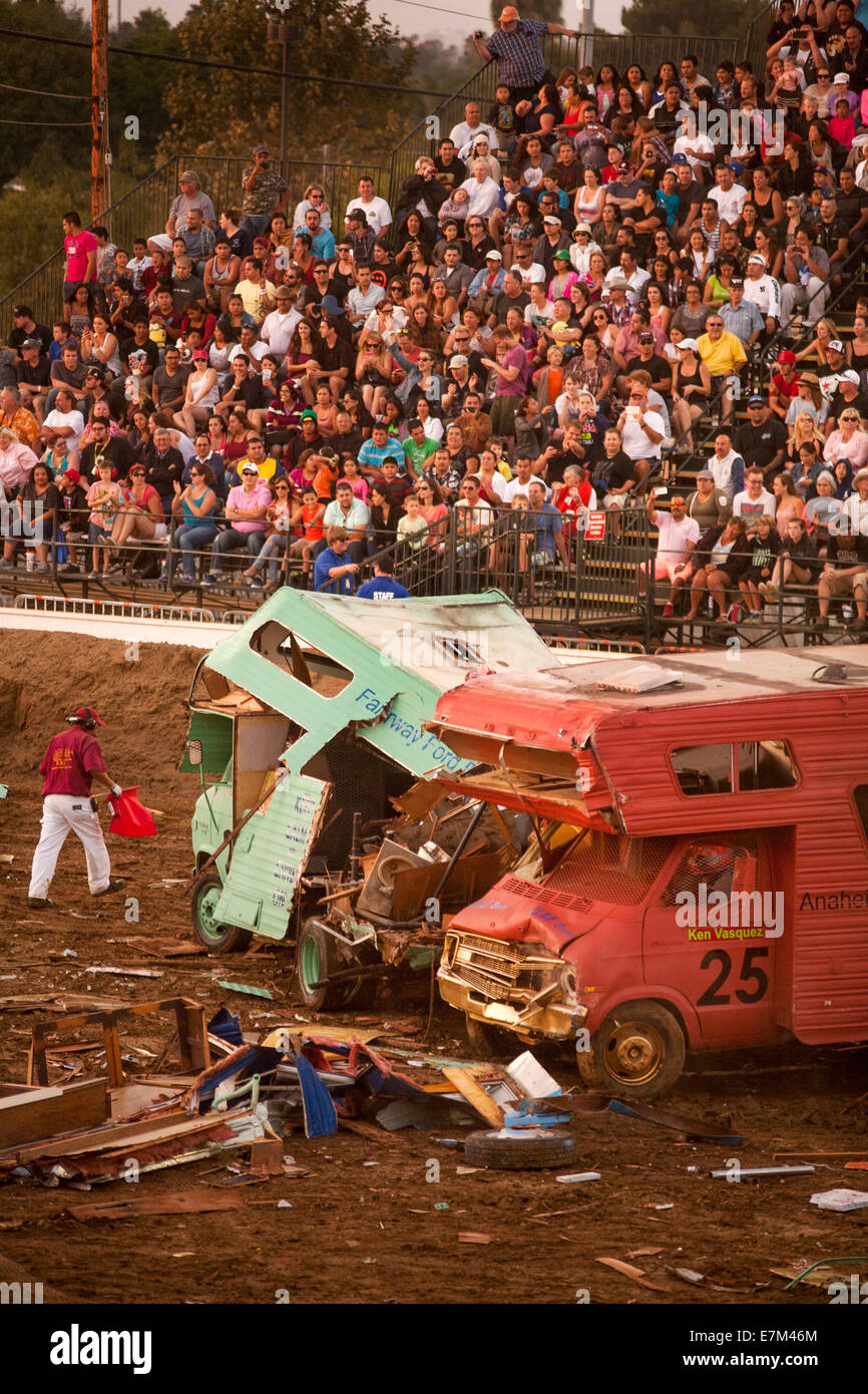 Bunt bemalten Reisemobile Absturz zusammen in einem Demolition Derby in der Abenddämmerung im Orange County Fair in Costa Mesa, Kalifornien. Das Objekt des Derby ist für die Fahrzeuge sich gegenseitig zu zerstören. Beachten Sie die Zuschauer im Hintergrund. Stockfoto