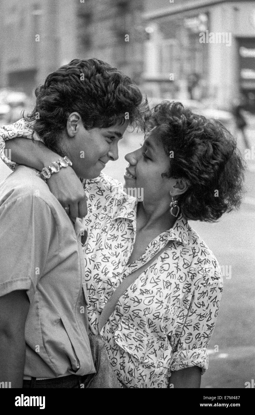 Ein schüchterne Hispanic junger Mann bekommt eine liebevolle Umarmung von seiner Freundin auf einer Straße in New York City. Stockfoto