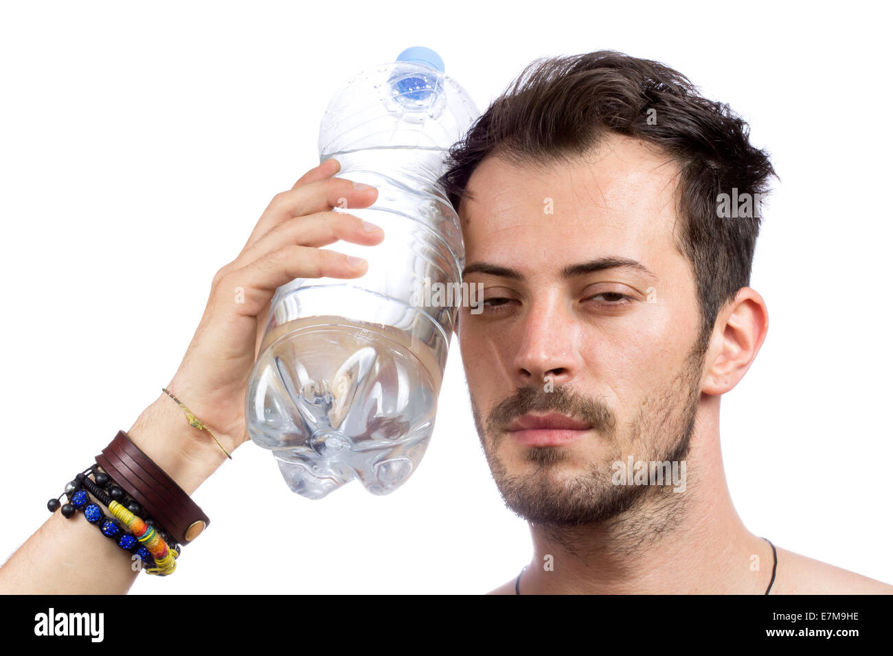 Mann hält eine Flasche Wasser auf dem Gesicht isoliert auf weißem Hintergrund Stockfoto