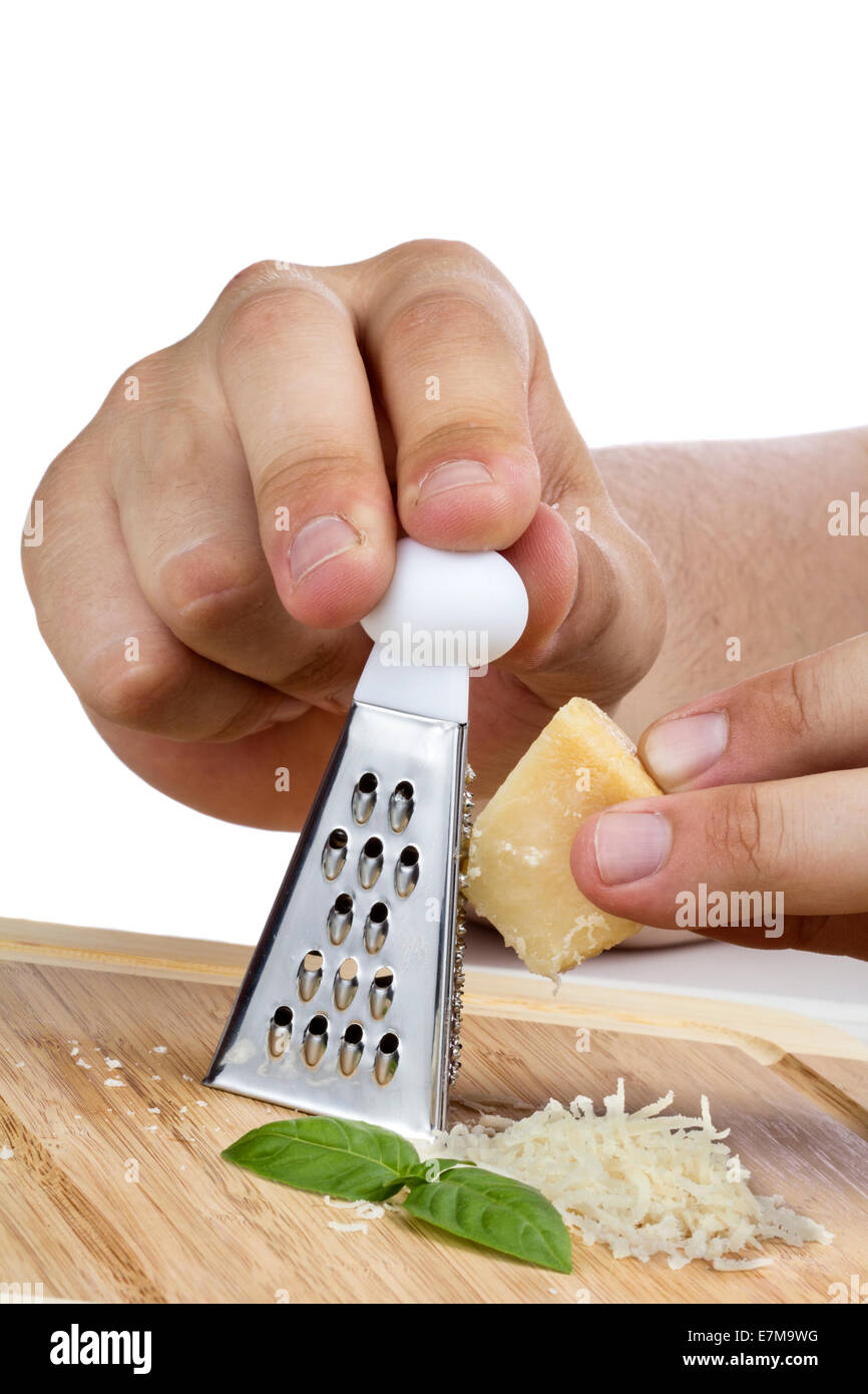 Schließen Sie herauf Bild der menschlichen Hand Reibe und Parmigiano-Käse in Holzplatte Stockfoto