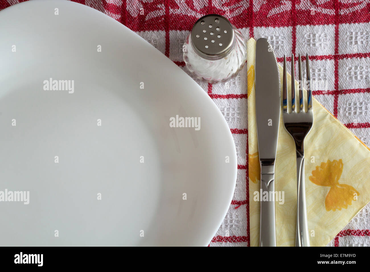 Ein Tisch mit Tellern, Besteck und einem karierten Tuch Stockfoto