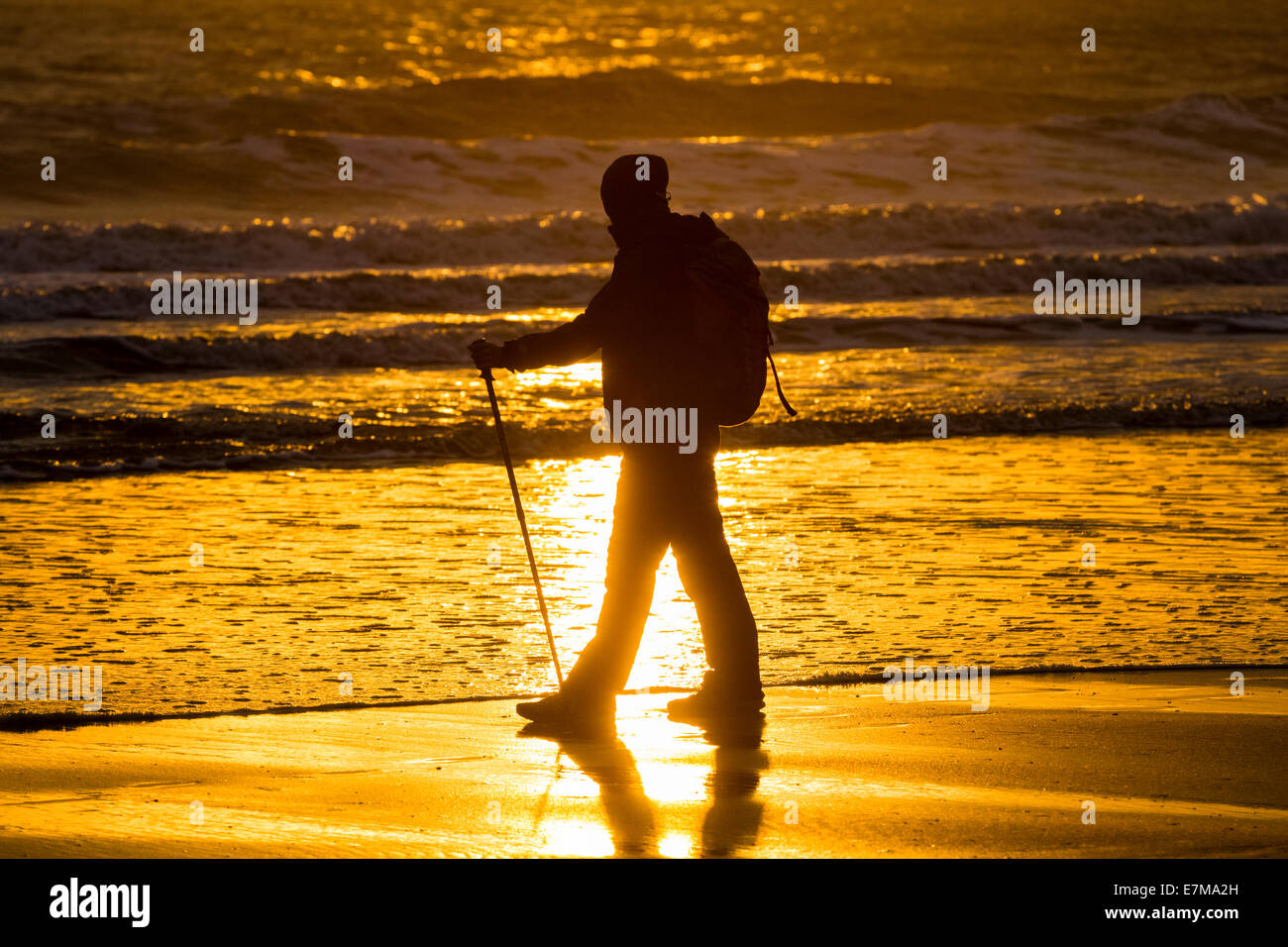 Eine weibliche Wanderer auf Seaton Carew Strand bei Sonnenaufgang, in der auf der 55 km Strecke der England Coast Path. Seaton Carew, England. Großbritannien Stockfoto