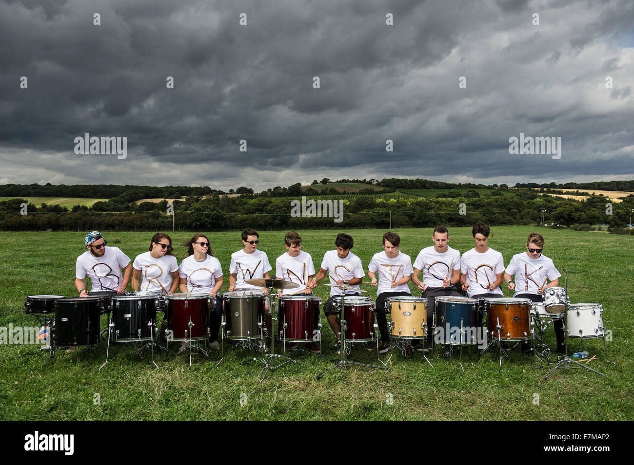 Die Legion des Schicksals Schlagzeug Ensemble begrüßt BesucherInnen zum Brownstock Festival in Essex. Stockfoto