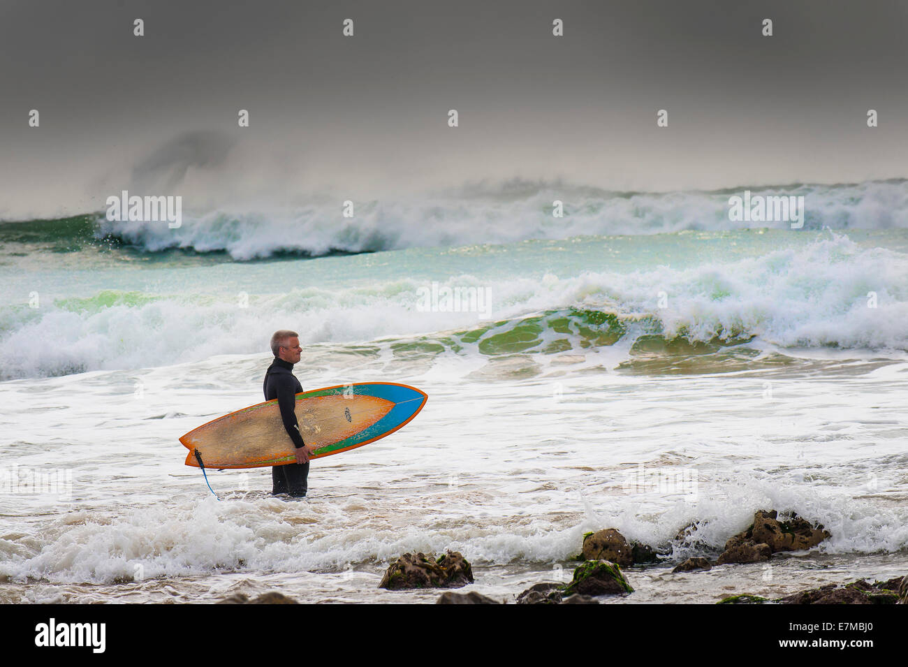 Ein Surfer in rauer See überprüfen die Wellen stehen. Stockfoto