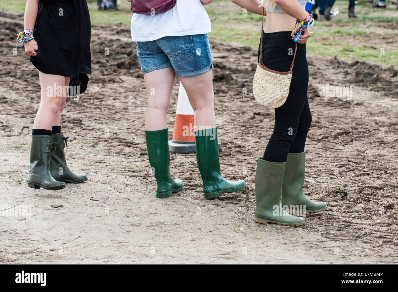 Junge Mädchen tragen kurze Hosen und Gummistiefel auf dem Brownstock Festival in Essex. Stockfoto