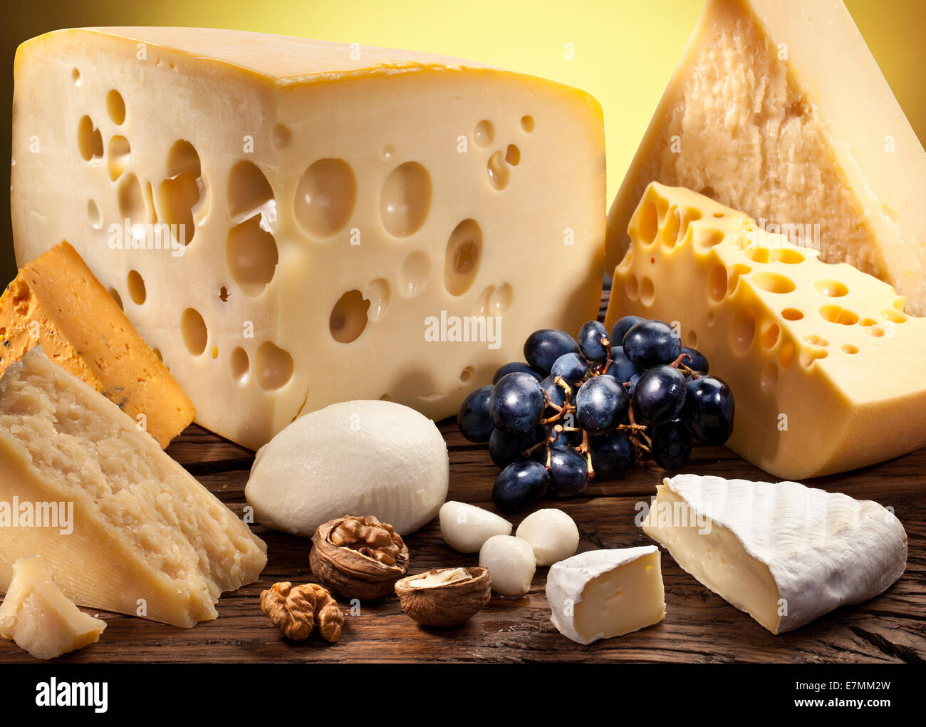 Verschiedene Arten von Käse über alten Holztisch. Stockfoto