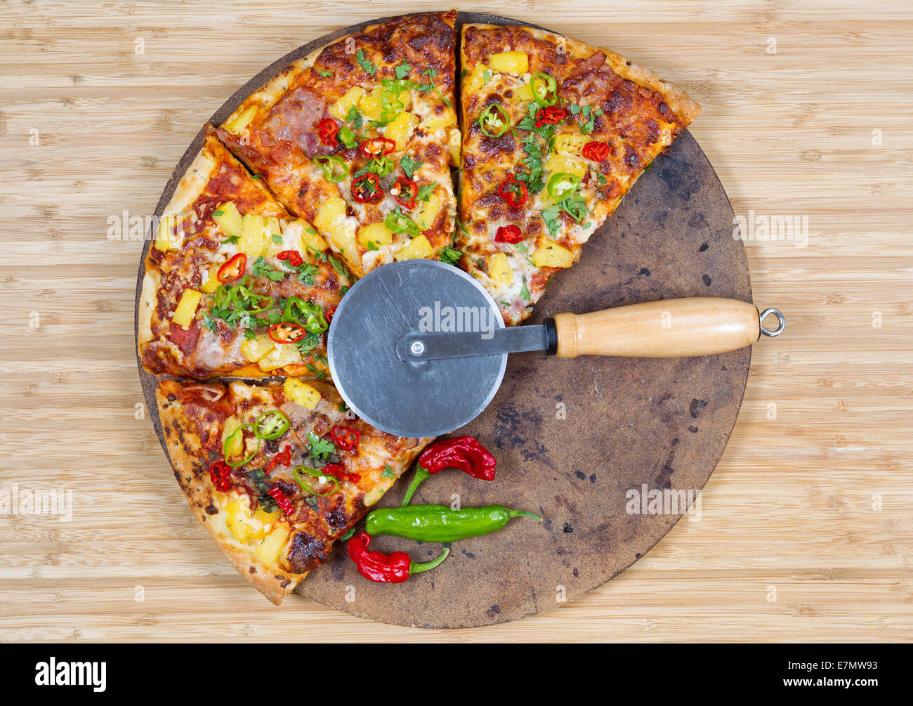 Draufsicht auf eine frisch gebackene Pizza mit Cutter auf Stein und natürlichen Bambus-board Stockfoto
