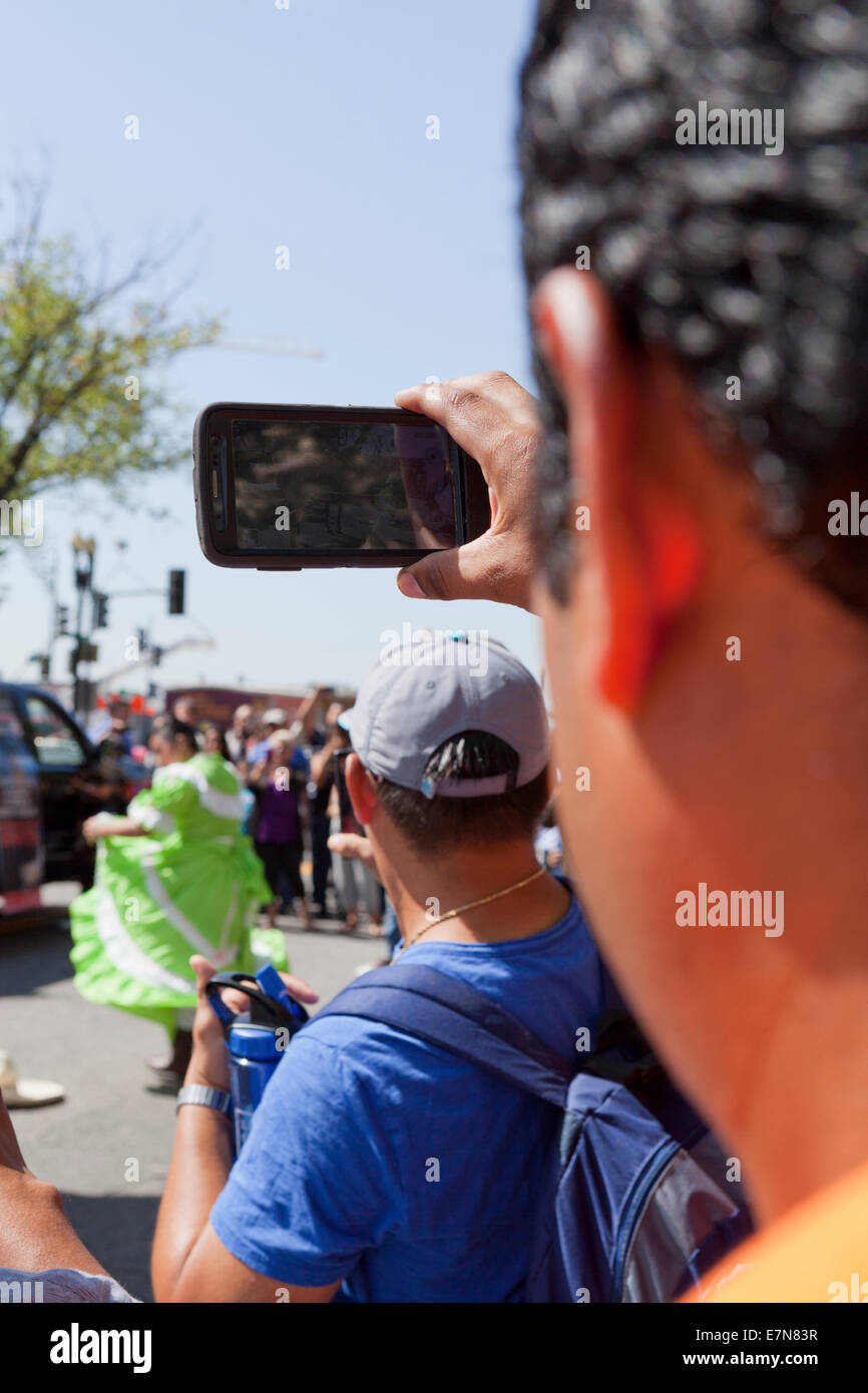 Mann für Videoaufnahmen der Veranstaltung bei einem Outdoor-Festival mit Smartphone - USA Stockfoto