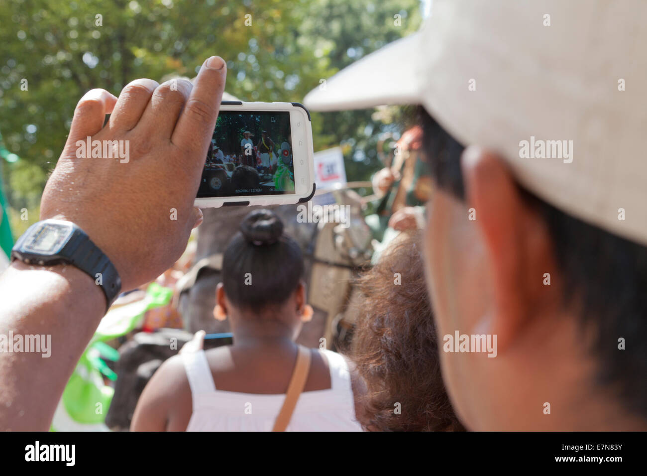 Mann für Videoaufnahmen der Veranstaltung bei einem Outdoor-Festival mit Smartphone - USA Stockfoto