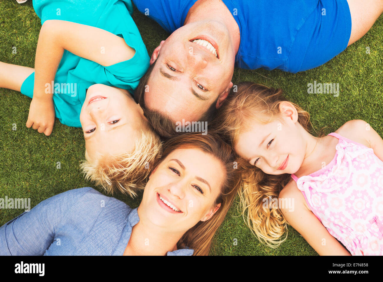 Porträt der glückliche Familie von vier draußen auf dem Rasen Stockfoto