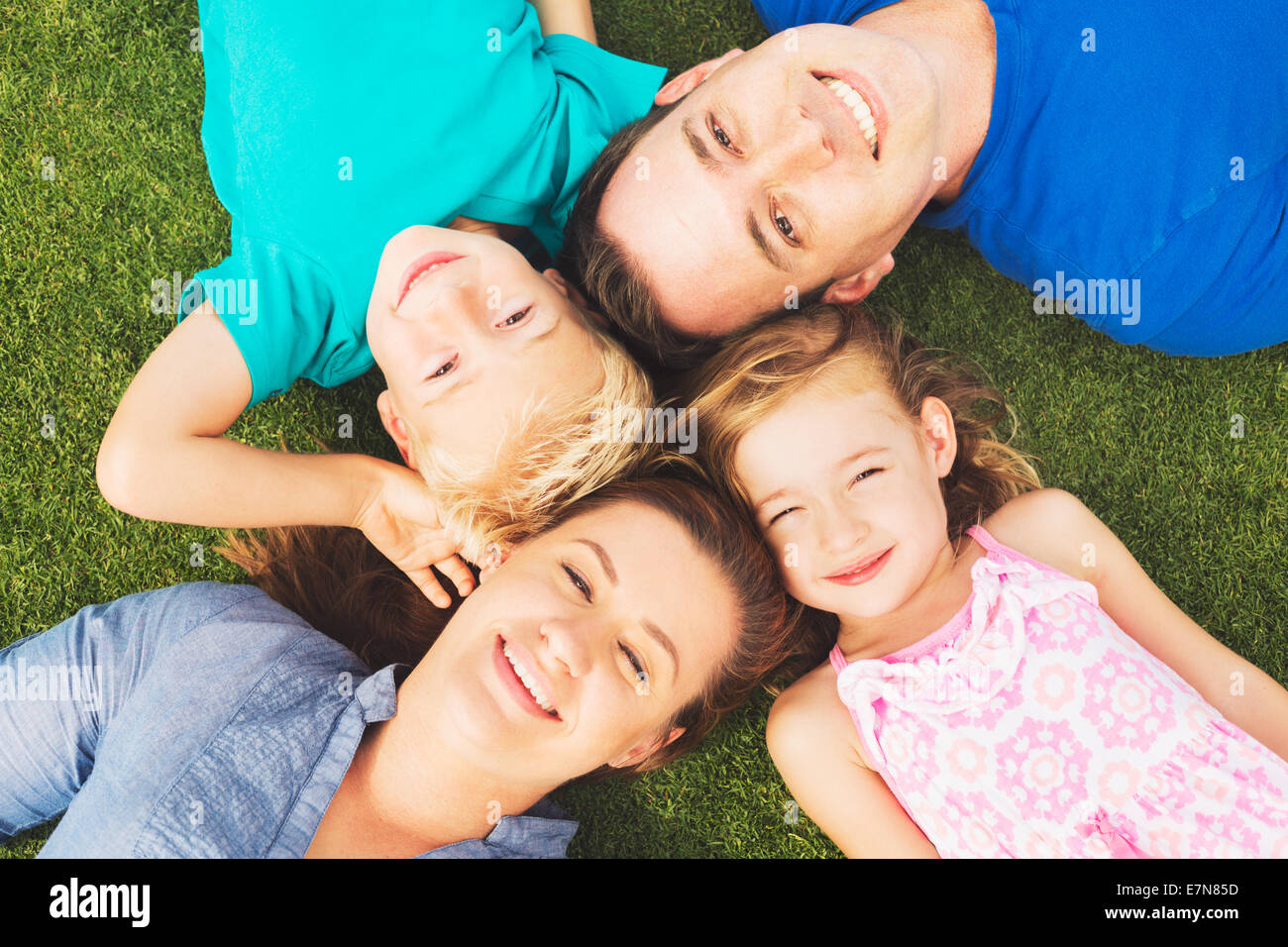 Porträt der glückliche Familie von vier draußen auf dem Rasen Stockfoto