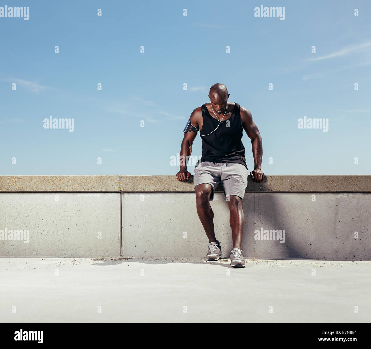 Muskulösen jungen Mann Atem nach seinen Lauf nehmen. Afrikanische Sportler im Freien mit Textfreiraum. Entspannen nach runnin männliche Läufer Stockfoto