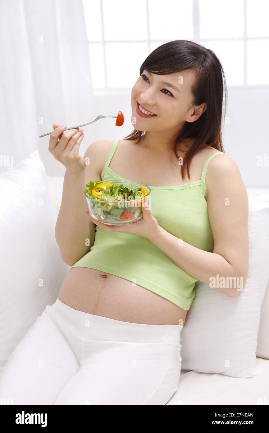 Schwangere Frau essen Salat Stockfoto