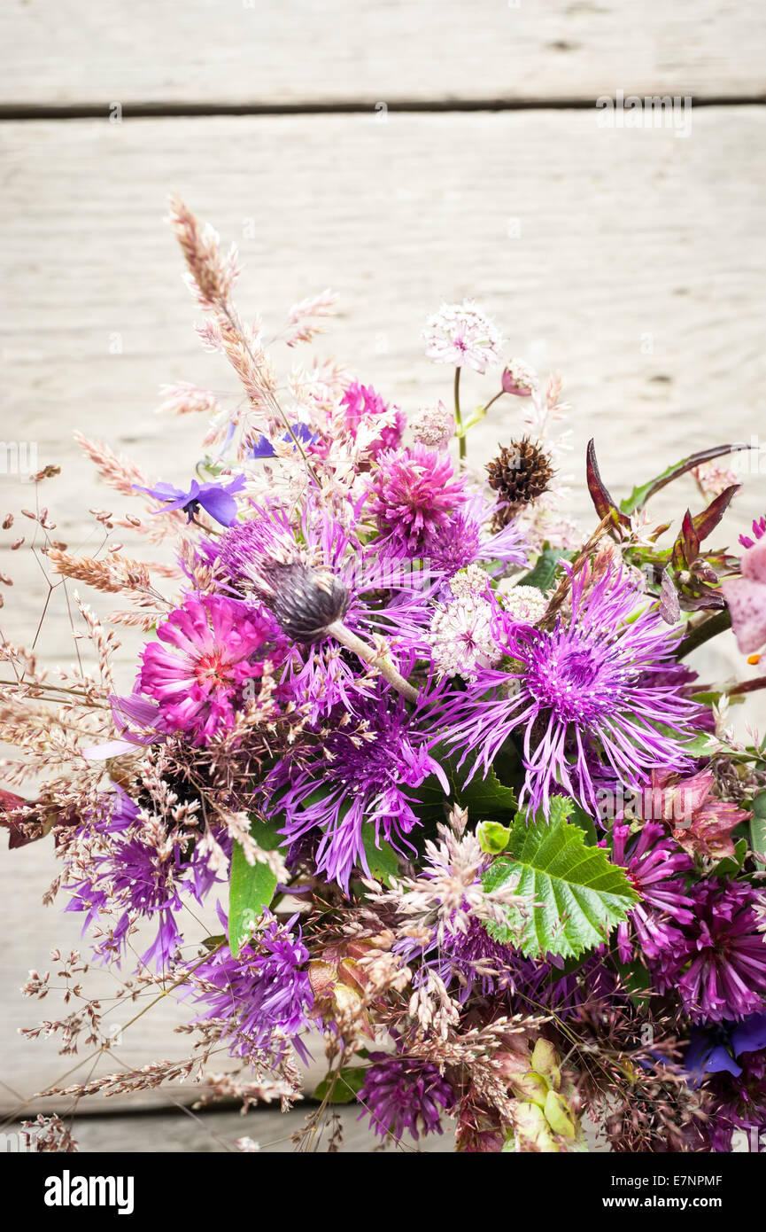 Schöne zarte Blumenstrauß Sommer Wiese auf hölzernen Hintergrund. Florale Komposition im ländlichen Vintage-Stil Stockfoto