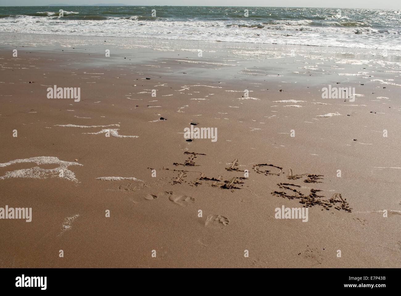 'Ich liebe das Meer' Nachricht geschrieben in nassem Sand mit ruhiger See im Hintergrund Stockfoto