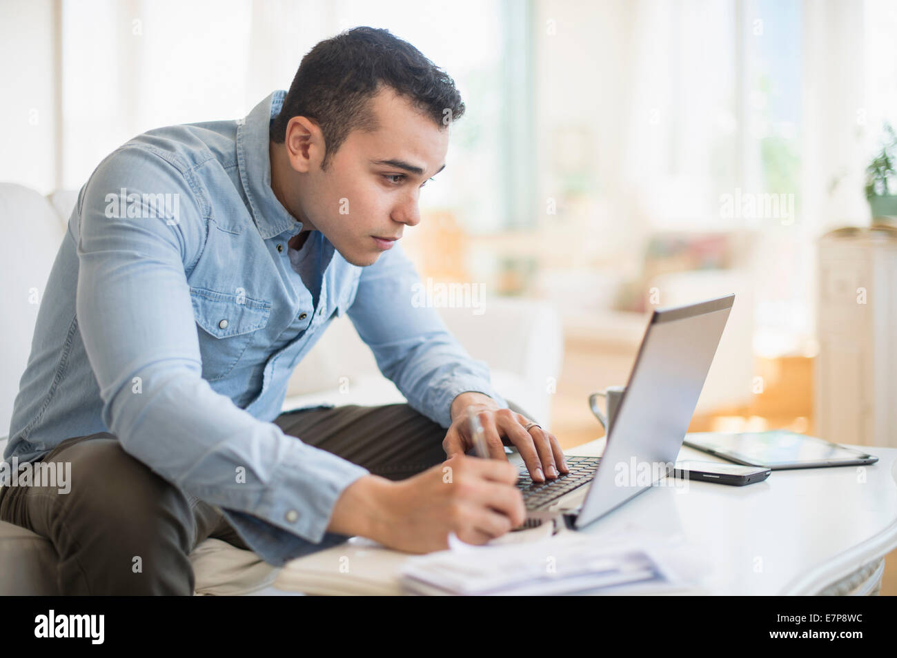 Mann arbeitet im Wohnzimmer Stockfoto