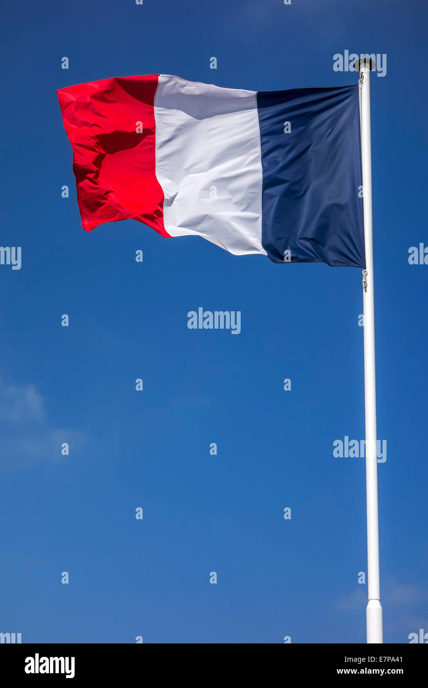 Französische Nationalflagge Frankreichs am Fahnenmast im Wind gegen blauen Himmel Stockfoto