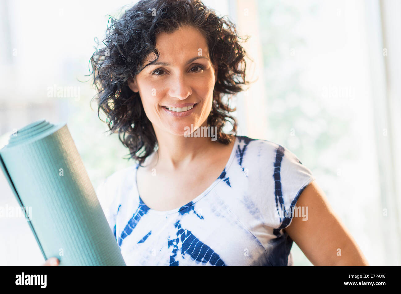 Portrait von lächelnden Frau mit Yoga-Matte Stockfoto