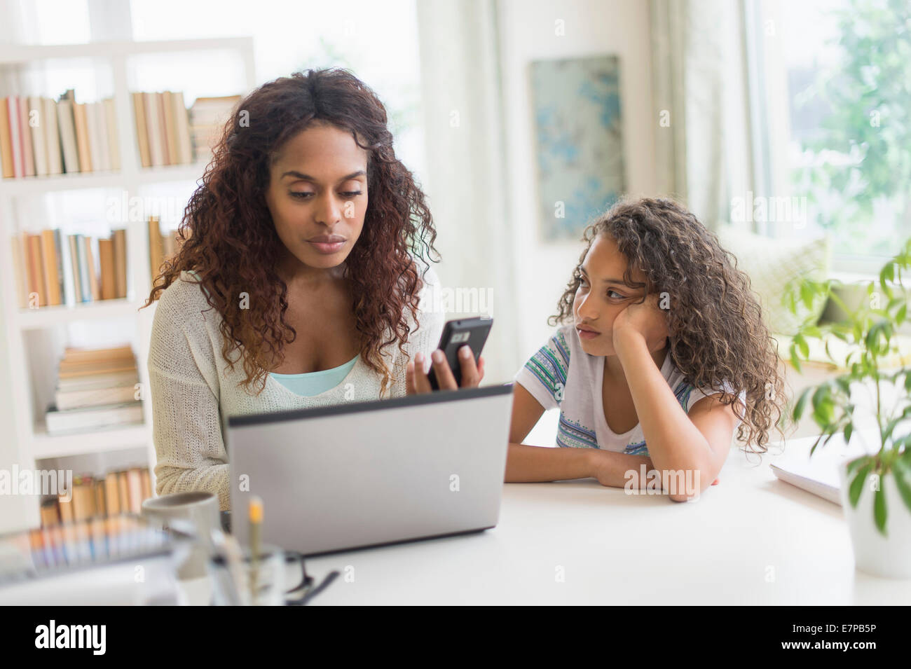 Mutter und Tochter (8-9) mit Laptop und Smartphone Stockfoto