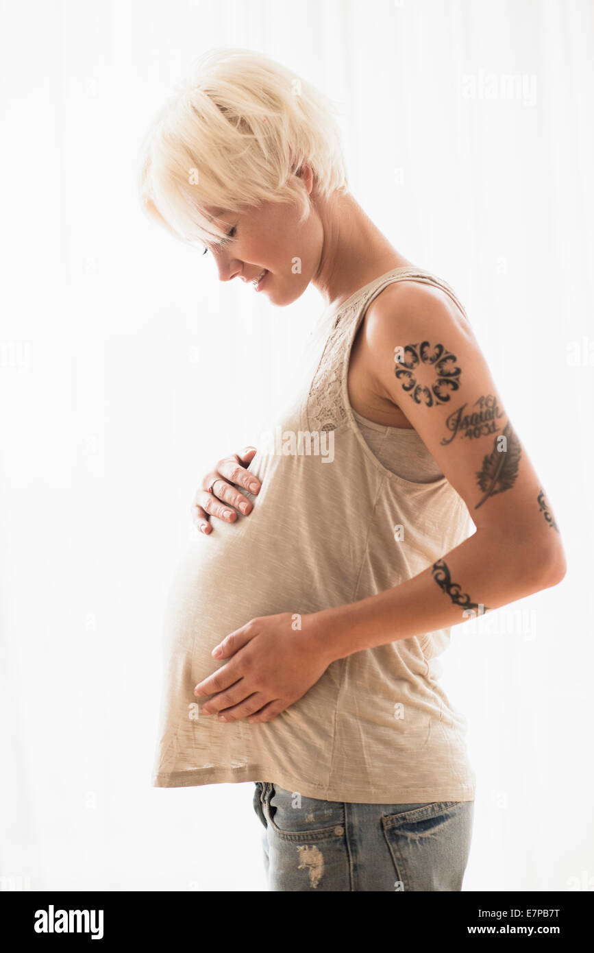 Schwangere Frau mit Händen auf Magen Stockfoto