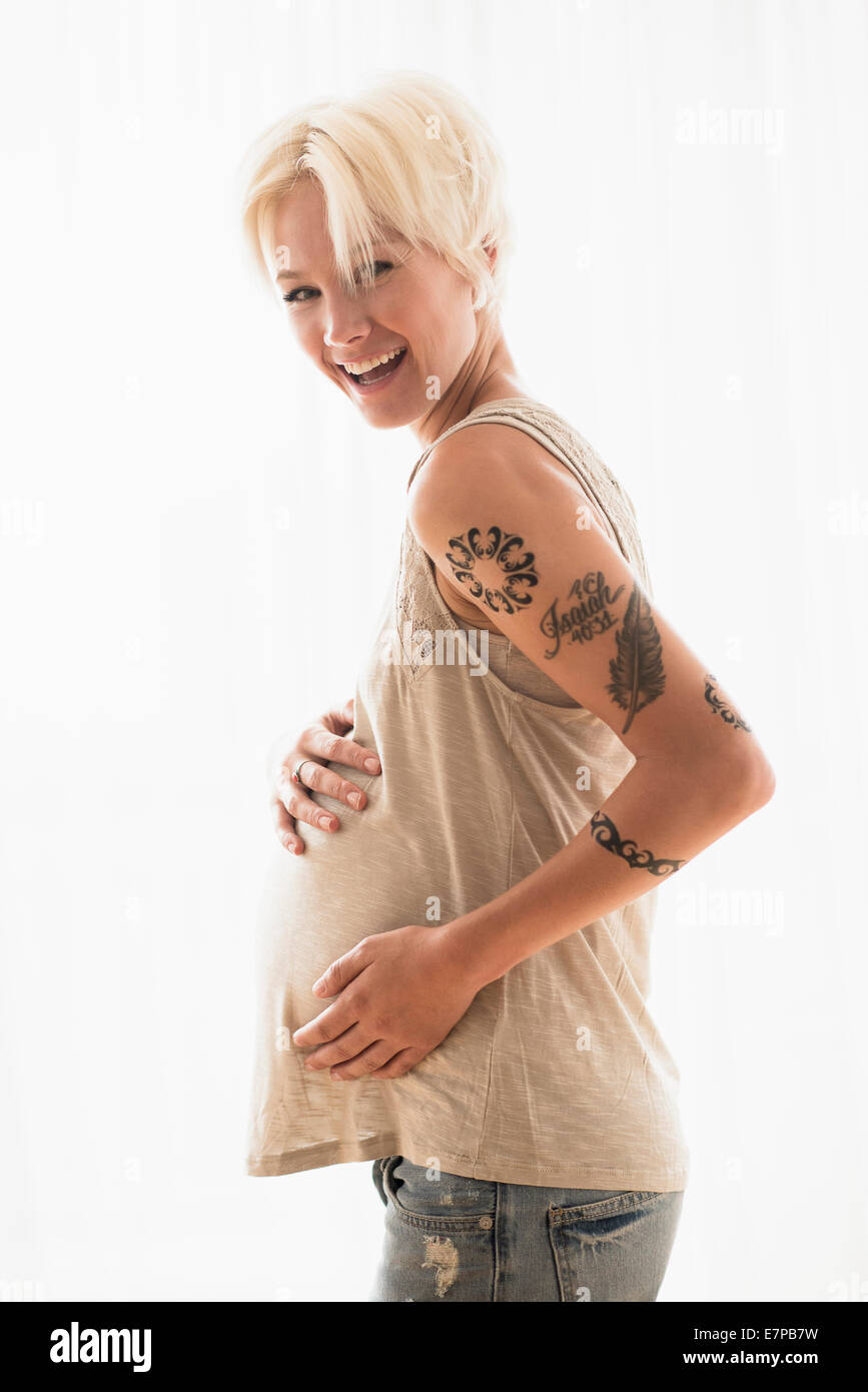 Schwangere Frau mit Händen auf Magen Stockfoto