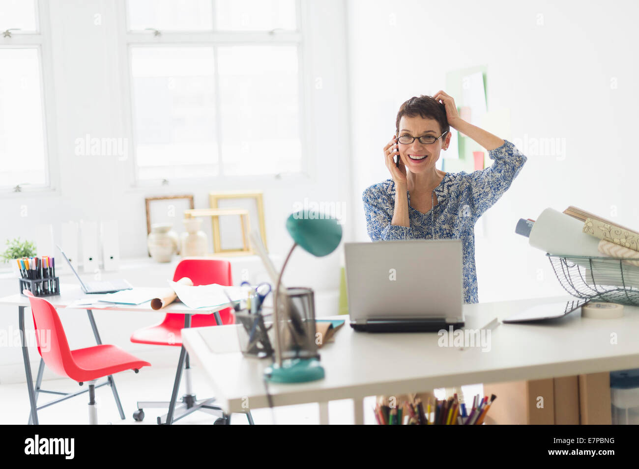 Senior Business-Frau mit Handy im Büro Stockfoto