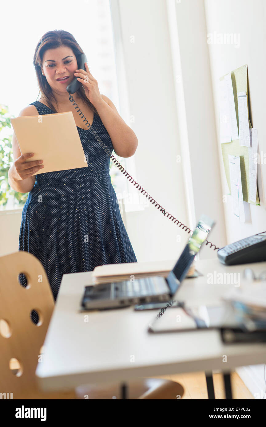 Frau mit Telefon im Büro Stockfoto