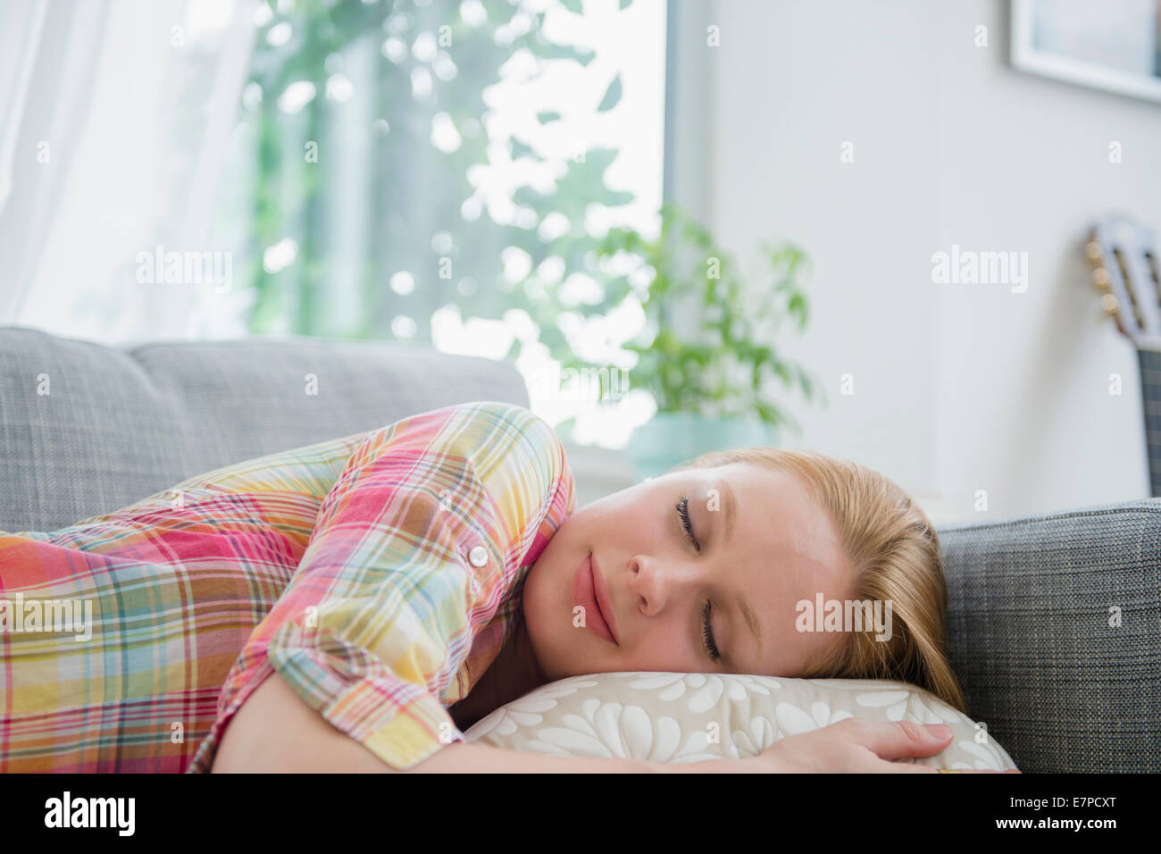 Junge Frau Nickerchen auf sofa Stockfoto