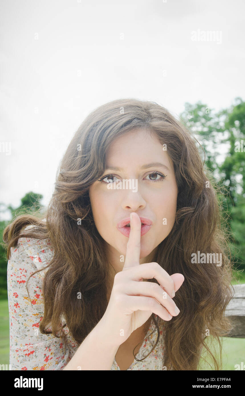 Porträt der Frau mit dem Finger auf die Lippen Stockfoto