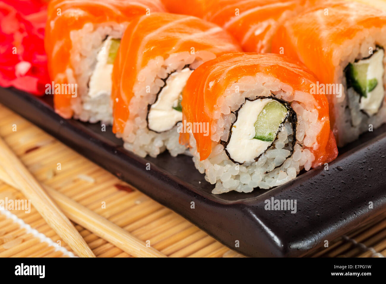 Lachs Sushi-Rollen auf einem hölzernen Hintergrund Stockfoto