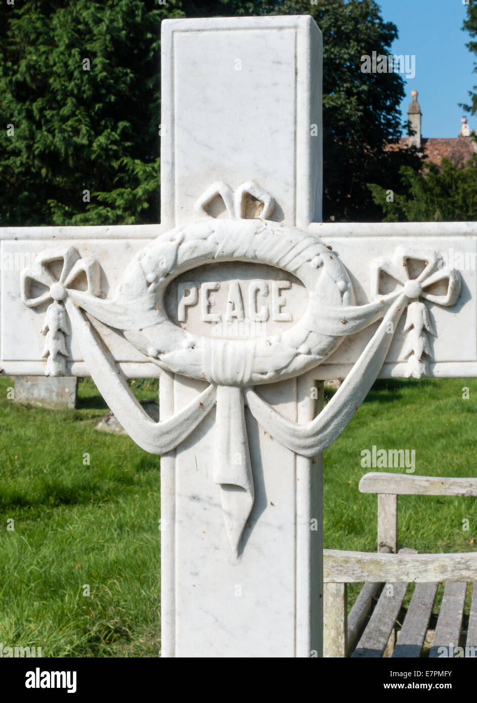 Aus Marmor Kreuz Grabstein mit dem Wort Frieden im Inneren eine Trophäe Kranz auf einem englischen Kirchhof Stockfoto