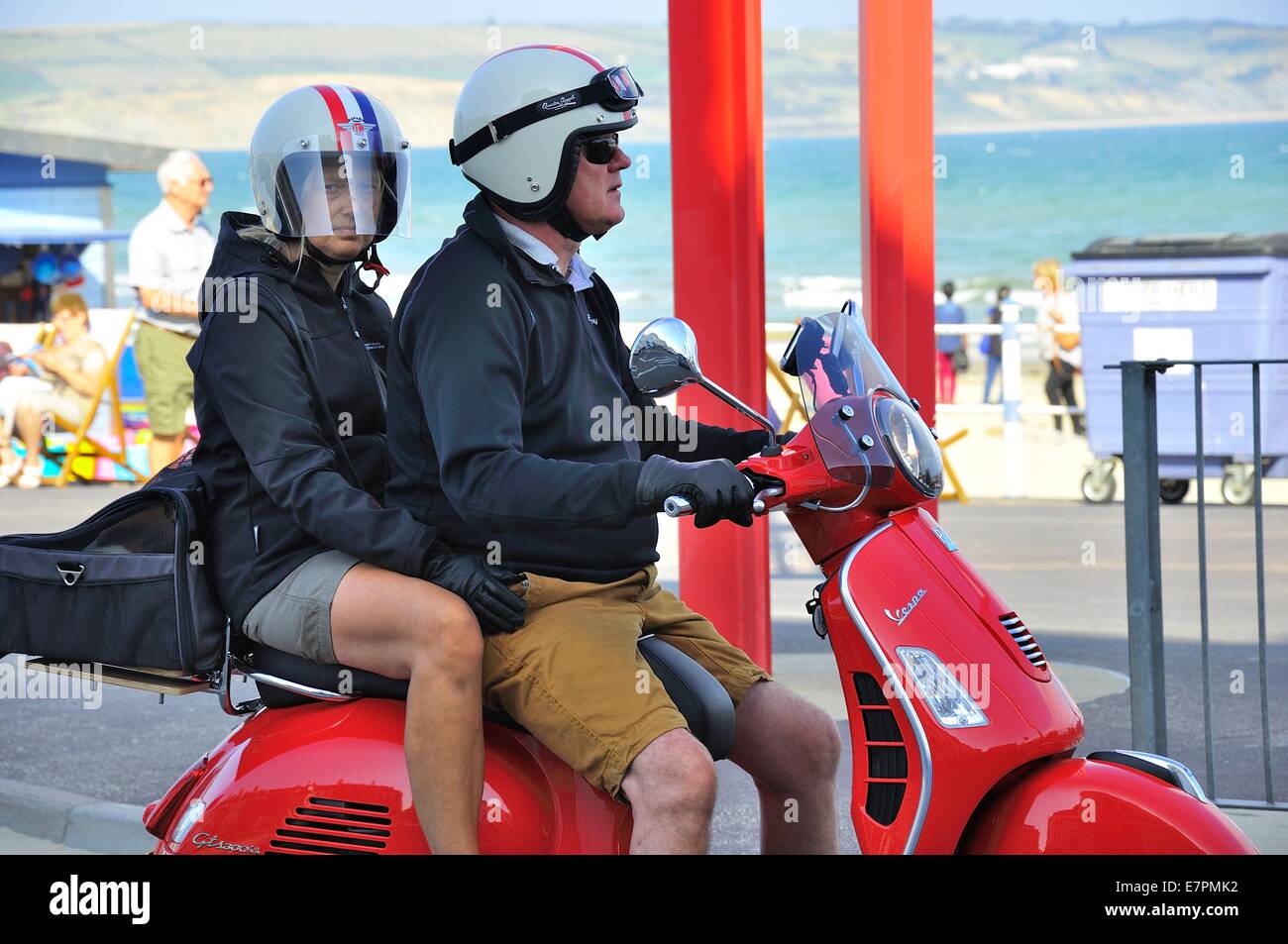 Mann und Frau Sozius Beifahrer auf roten Vespa Motorroller. Stockfoto