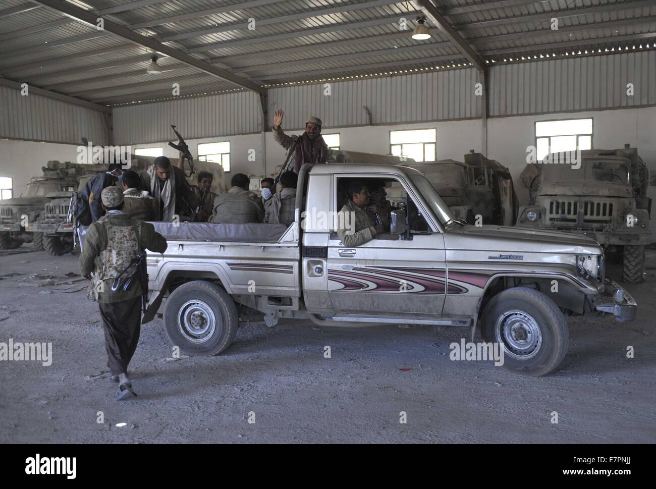 Sanaa, Jemen. 22. Sep, 2014. Schiitischen Houthi-Rebellen fahren ein Militärfahrzeug in der Baracke der 1. US-Panzerdivision wurde kontrolliert von den Rebellen in Sanaa, Jemen, am 22. September 2014. Die schiitischen Houthi-Rebellen am Montag Kontrollpunkte eingerichtet und Kämpfer um wichtige staatliche Institutionen in Jemens Hauptstadt Sanaa zu schützen, wie sie die Stadt nach einer Woche kämpfen gegen die Armee und die sunnitischen Miliz überrannten bereitgestellt. Bildnachweis: Hani Ali/Xinhua/Alamy Live-Nachrichten Stockfoto