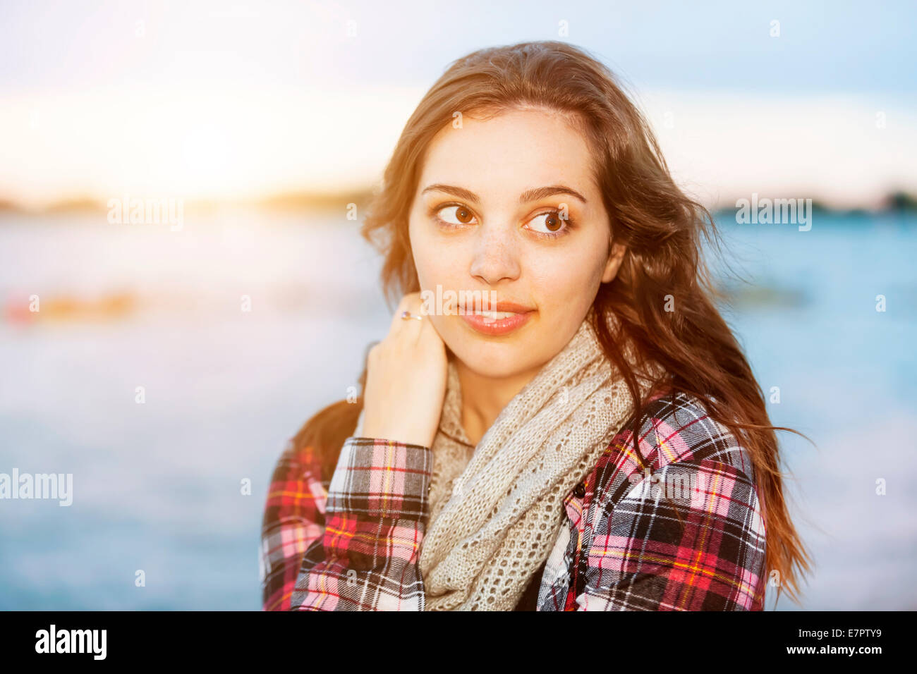 Ehrliche Portrait von junge Brünette Frau am Sonnenuntergang wegschauen mit Textfreiraum Stockfoto