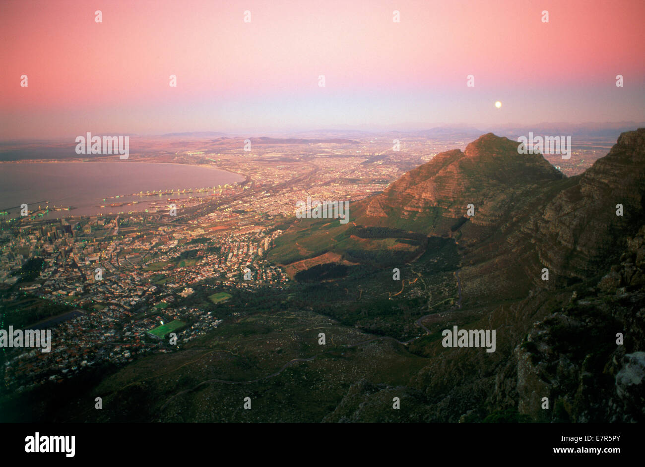 Mond über Kapstadt und die Tafelbucht in der Dämmerung vom Tafelberg Stockfoto