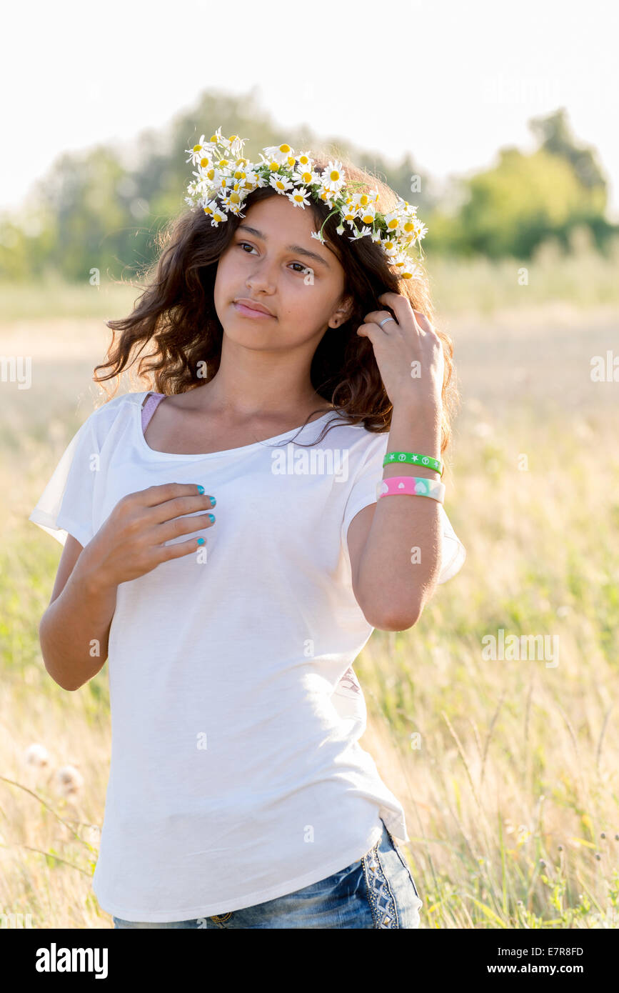 Teengirl mit einem Kranz aus Margeriten in Feld Stockfoto