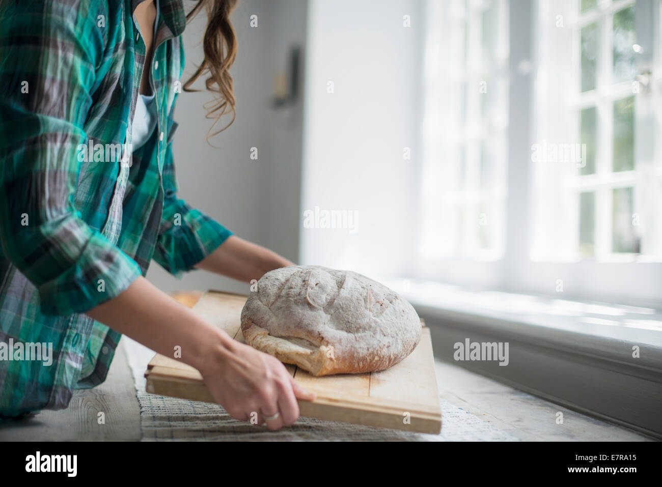 Ein Familientreffen. Eine Frau, die ein frisch gebackenes Brot. Stockfoto