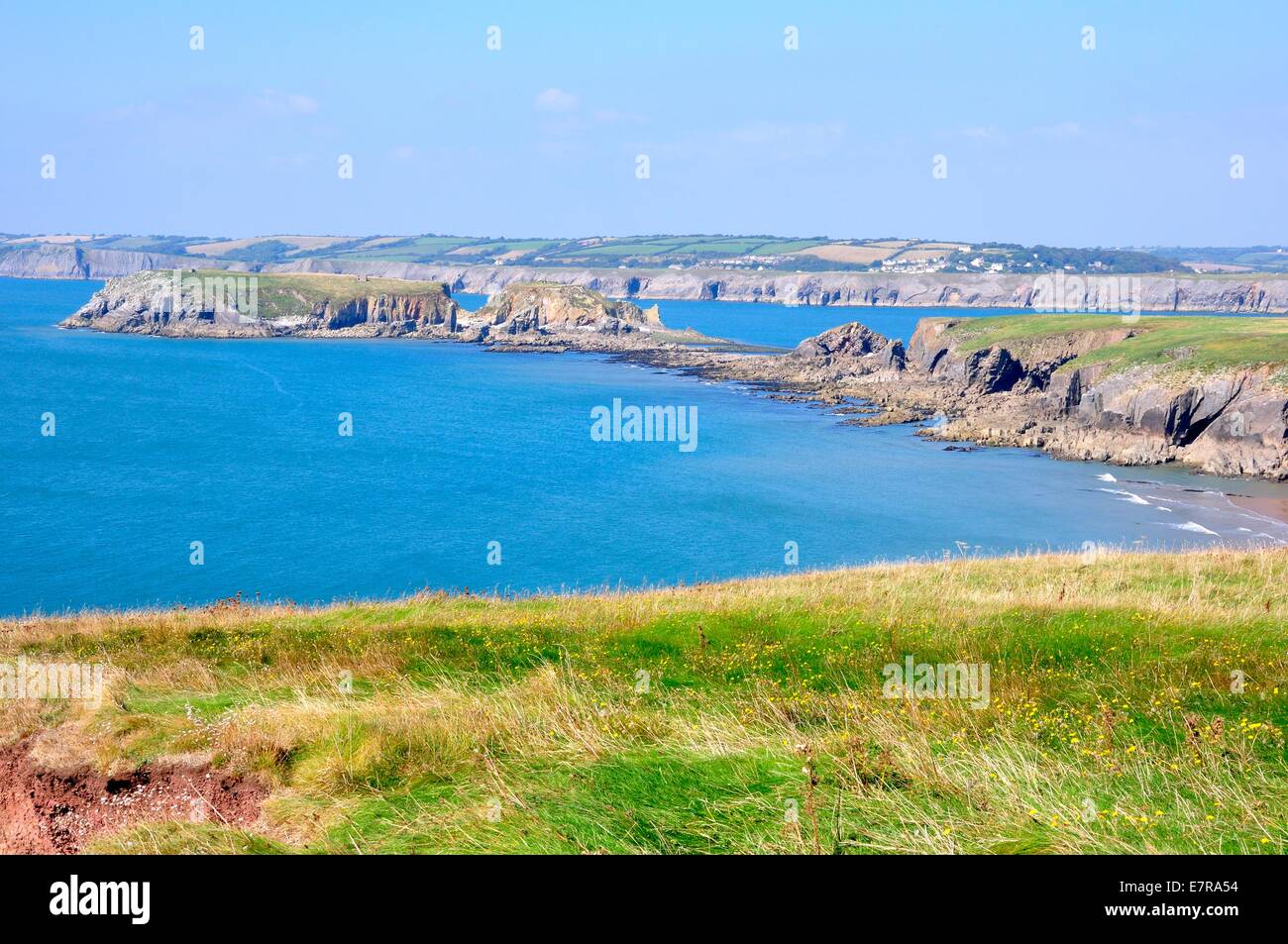 Blick von einer hohen Klippe auf Caldey Island, Pembrokeshire, Wales.Mainland Wales in der Ferne Stockfoto