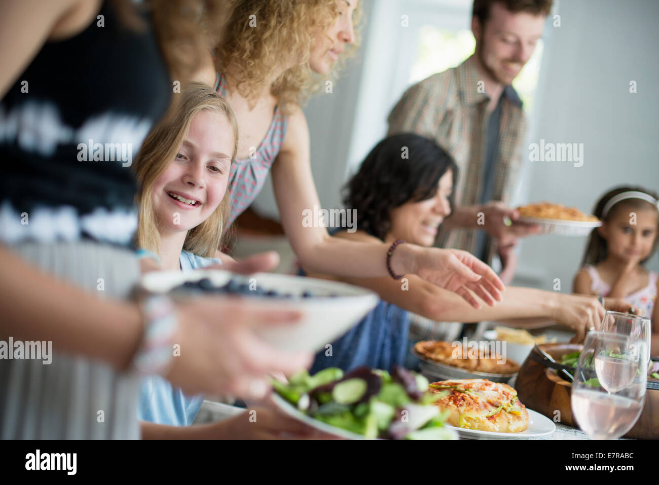 Ein Familientreffen für eine Mahlzeit. Erwachsene und Kinder an einem Tisch. Stockfoto