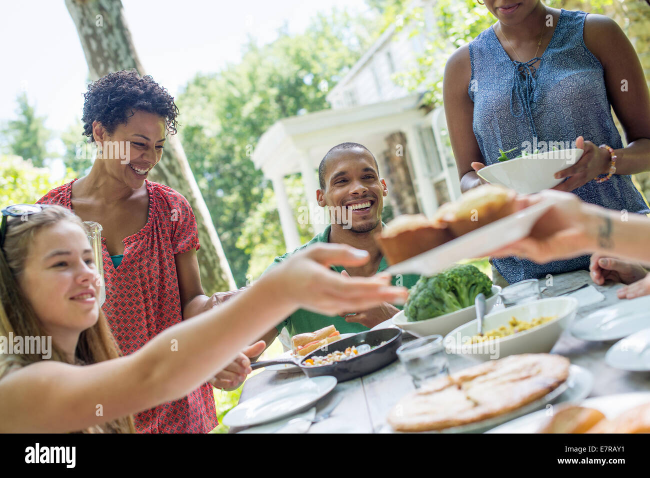 Ein Familientreffen, Männer, Frauen und Kinder an einem Tisch in einem Garten im Sommer. Stockfoto