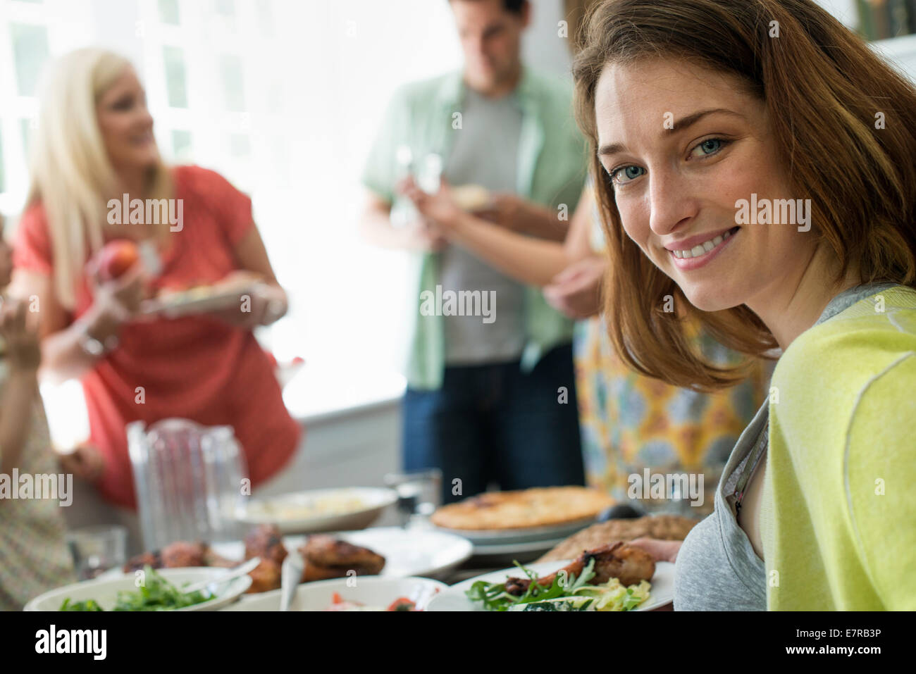 Ein Familientreffen für eine Mahlzeit. Erwachsene und Kinder an einem Tisch. Stockfoto