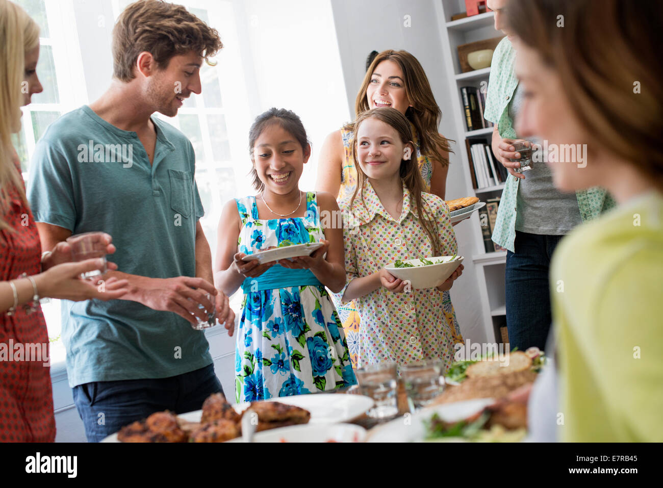 Ein Familientreffen für eine Mahlzeit. Erwachsene und Kinder an einem Tisch. Stockfoto