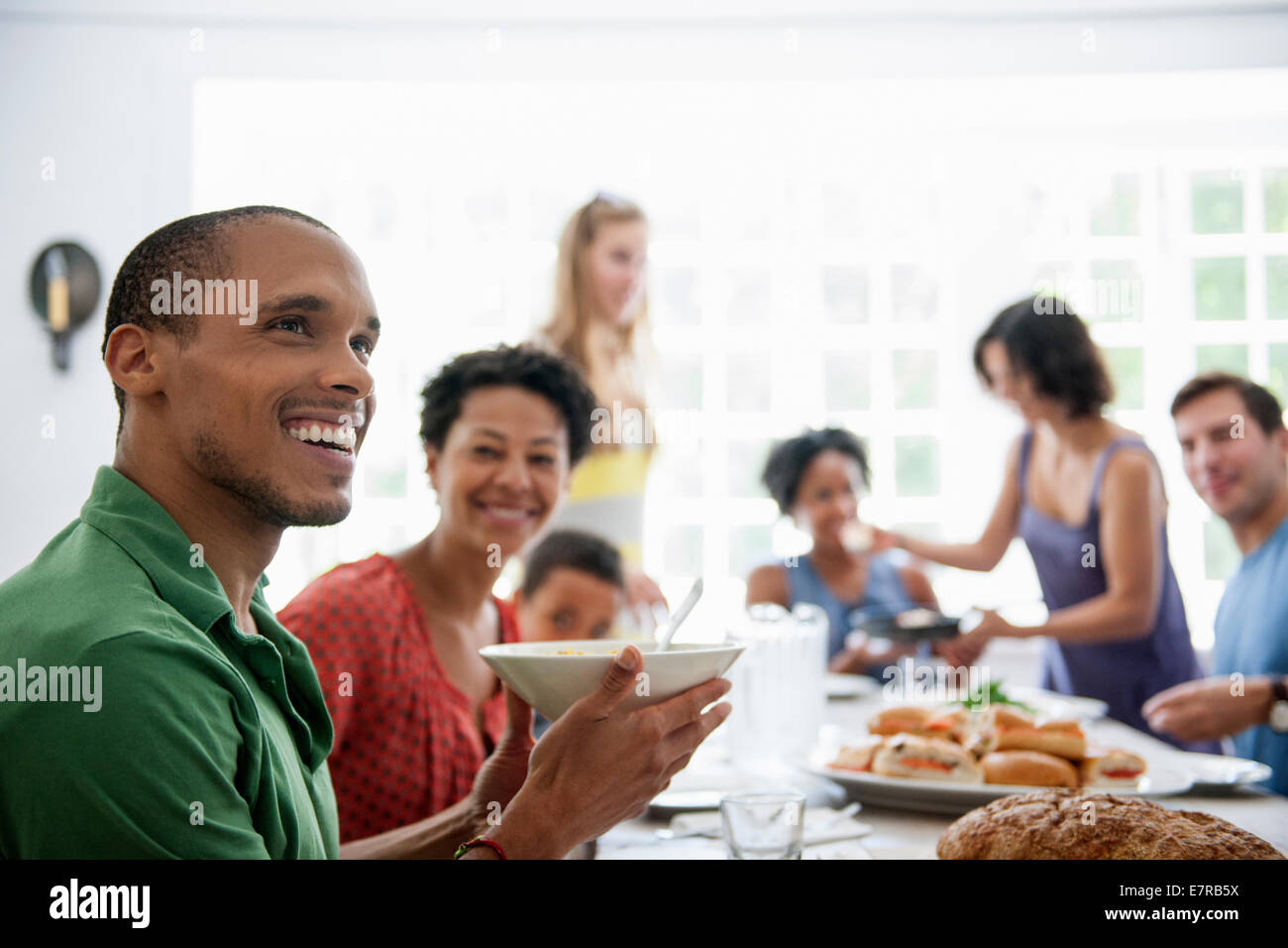 Ein Familientreffen für eine Mahlzeit. Erwachsene und Kinder an einem Tisch. Stockfoto