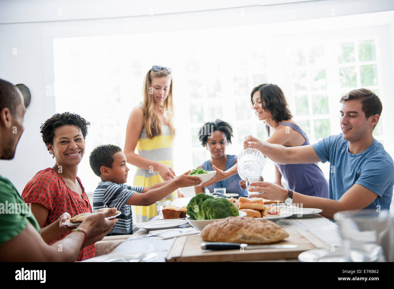 Ein Familientreffen für eine Mahlzeit. Erwachsene und Kinder an einem Tisch. Stockfoto