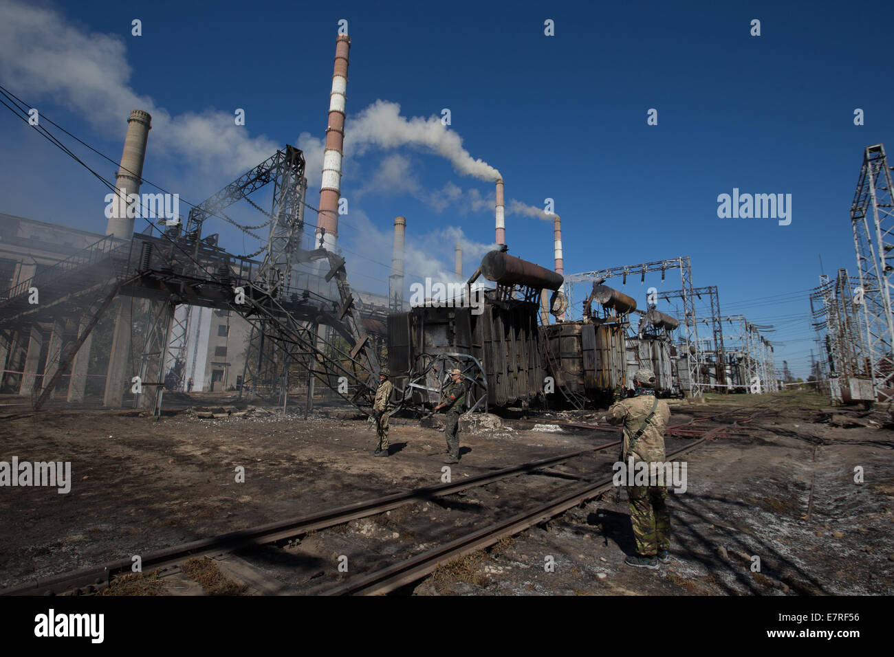 Soldaten mit der ukrainischen Freiwilligen Bataillon "Aidar" vor verbrannten Transformatoren auf dem Gelände des Elektrizitätswerk "TES" in Shchastya, eine Ortschaft in der Nähe von Lugansk, Ukraine, 18. September 2014 stehen. Sie wurden durch Mörtel Bombardierung von pro-russischen Separatisten zerstört. Das Kraftwerk liefert Strom zu einem großen Teil von Lugansk und Umgebung. Schäden führen zu Black Outs in den Bereichen Novoajdar, Starobielsk, Severodonezk und Stanitschno-Lugansk. Foto: Jan A. Nicolas/dpa - NO-Draht-Dienst- Stockfoto