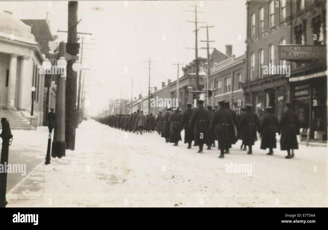 Dieses Foto zeigt das 77. Wentworth Regiment, das auf der King Street nach Westen marschiert, wahrscheinlich während des frühen 20. Jahrhunderts. Er fängt eine Militärprozession auf einer Stadtstraße ein, die Kriegsaktivitäten widerspiegelt. Stockfoto