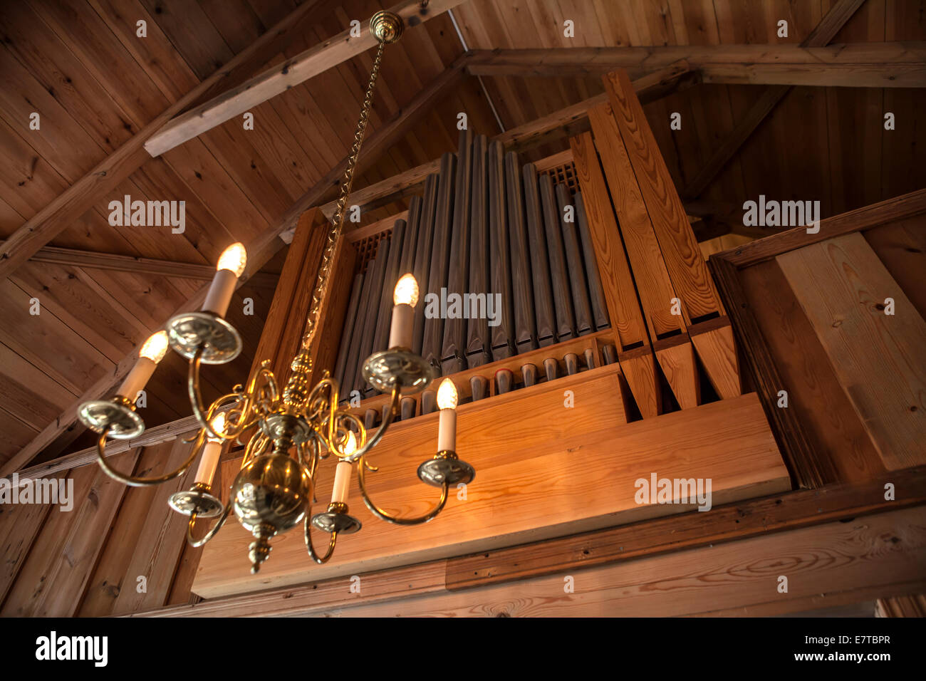 Orgel in einer alten hölzernen Kapelle mit einer Pendelleuchte Stockfoto