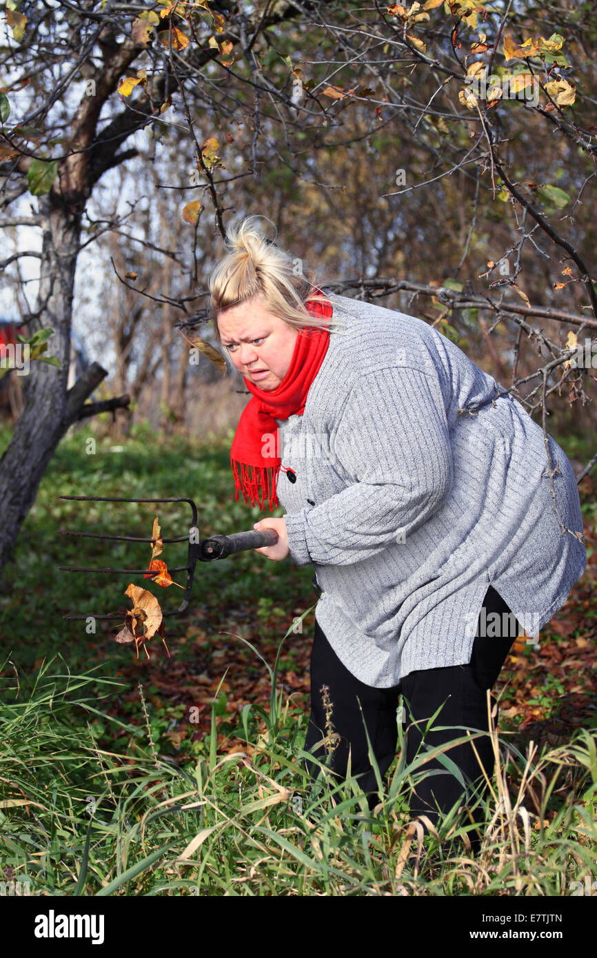 Großen mad Bäuerin mit Heugabel im Garten Stockfoto