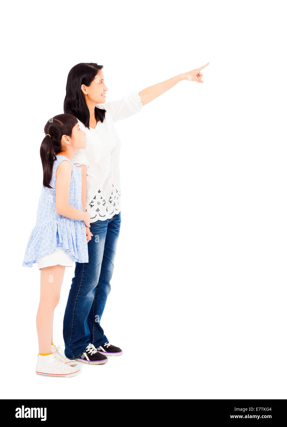 Glückliche Mutter und Tochter auf der Suche und zeigt auf weißem Hintergrund Stockfoto