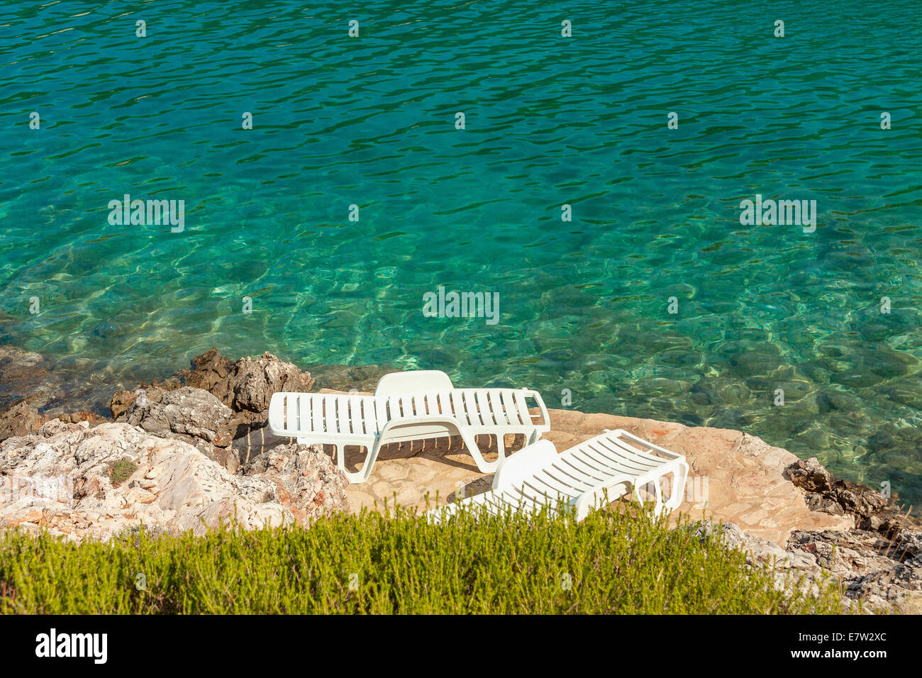 Liegestühle in der Rosohotnica Bay in Basina Dorf, Insel Hvar, Kroatien Stockfoto